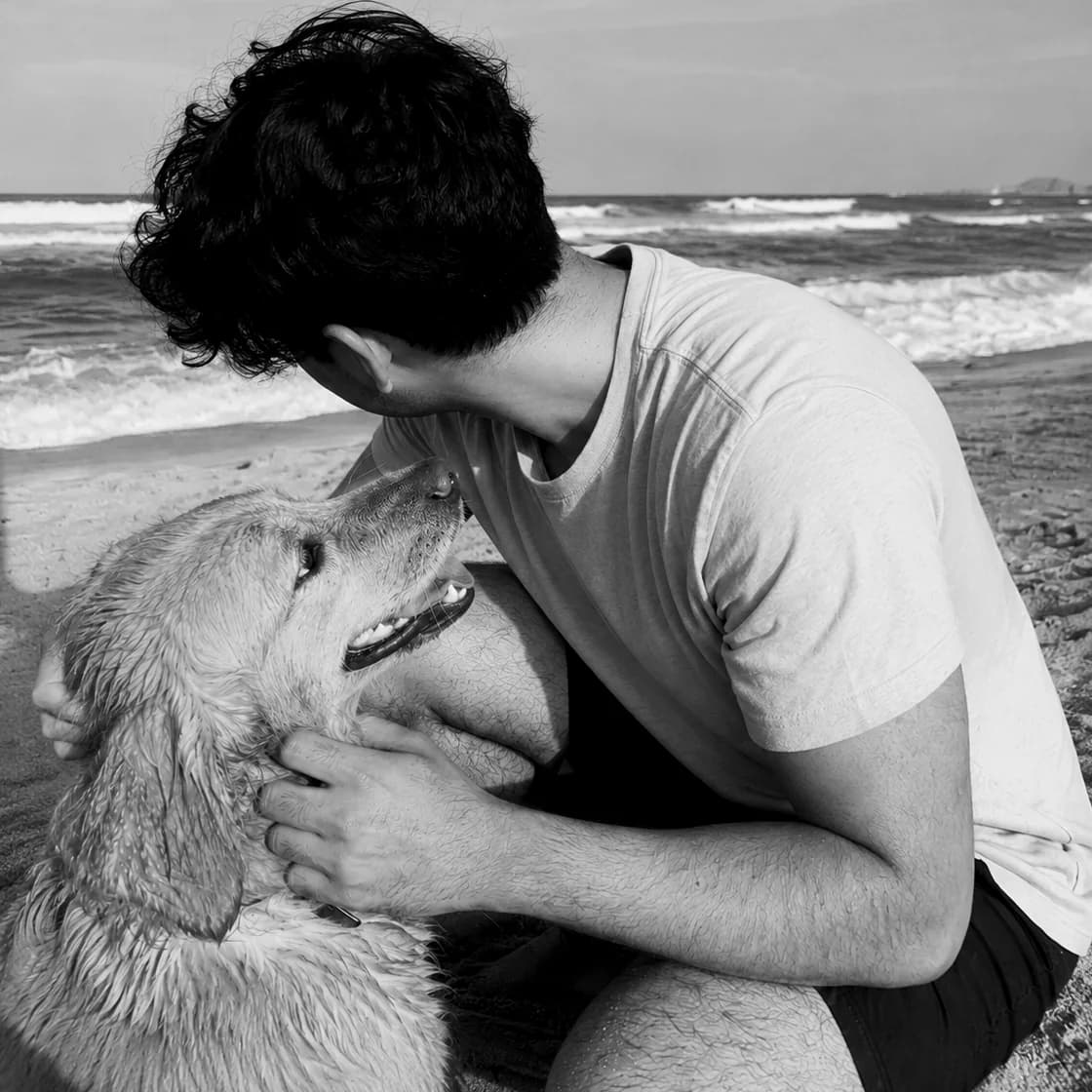 Taha with a dog beside the sea
